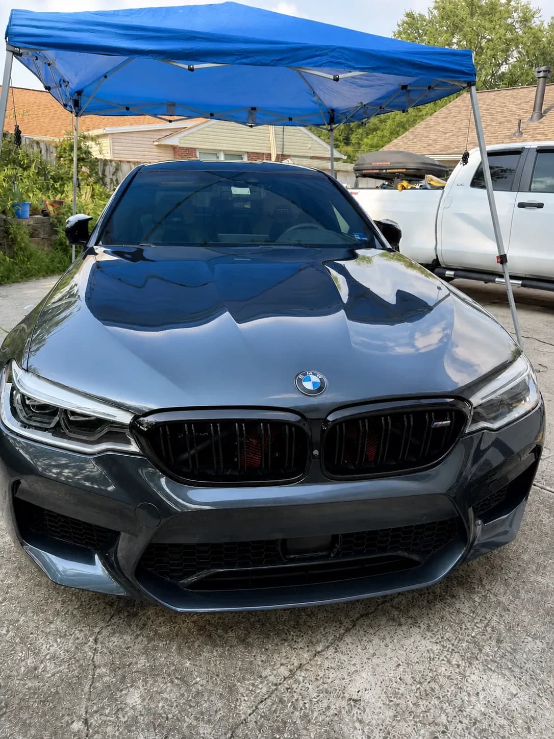 Detailed BMW under a mobile canopy with a glossy ceramic-protected finish