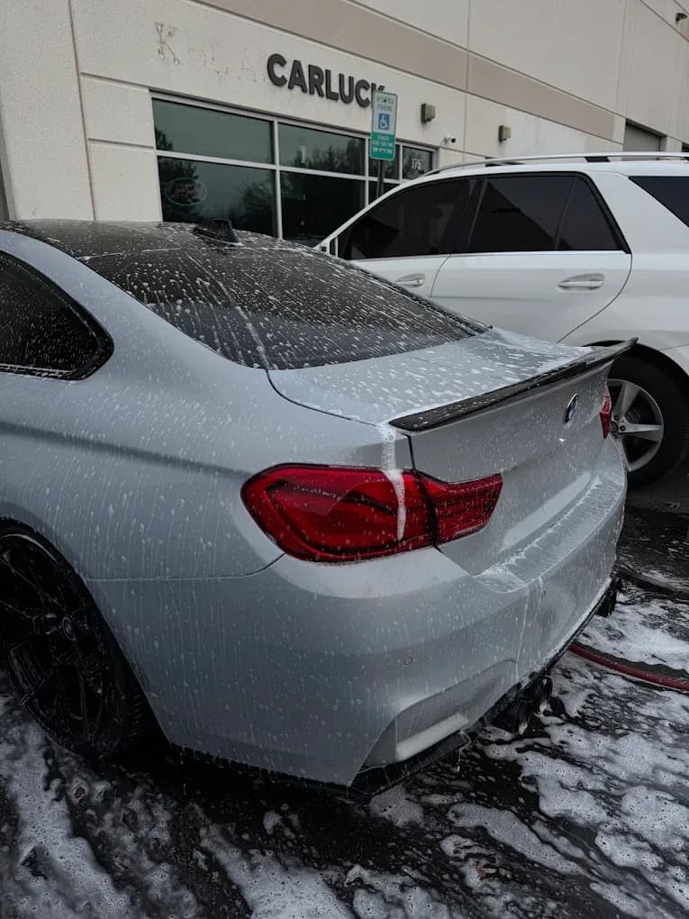 White BMW covered in foam during a mobile exterior wash