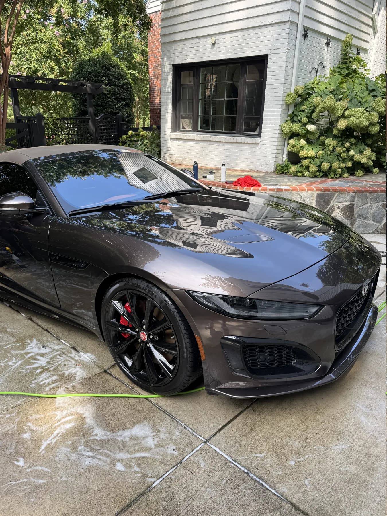 Dark gray Jaguar with a deep reflective finish after a mobile exterior detail