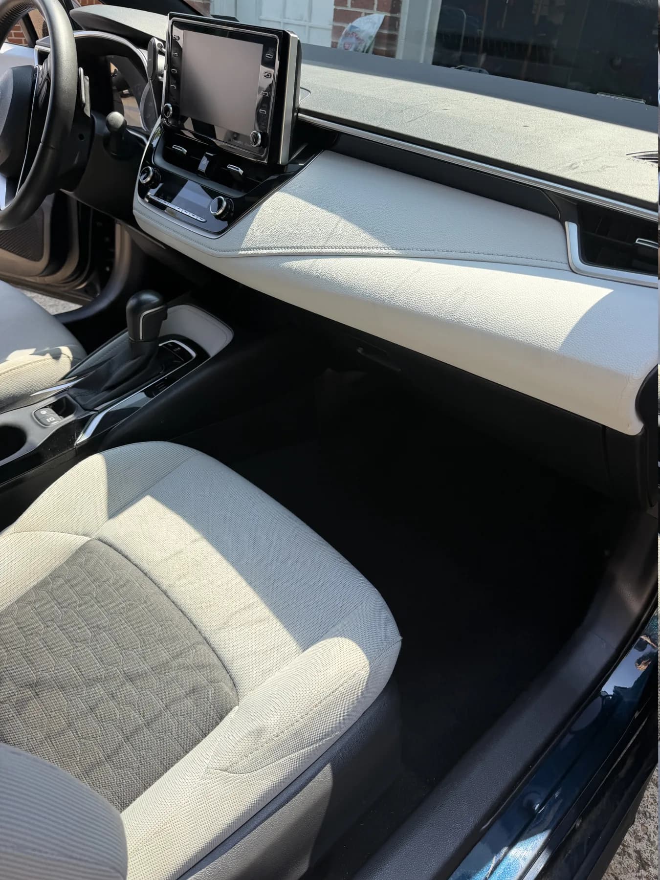 Freshly cleaned light-colored front seat, dashboard, and footwell