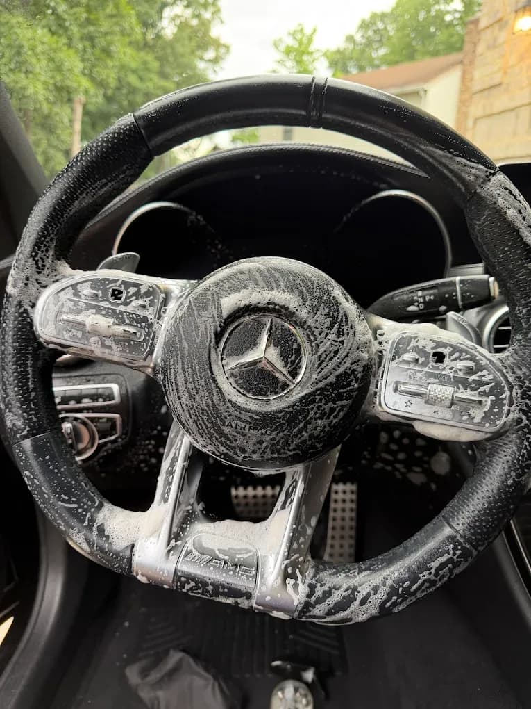 Mercedes steering wheel covered in cleaning solution during an interior detail