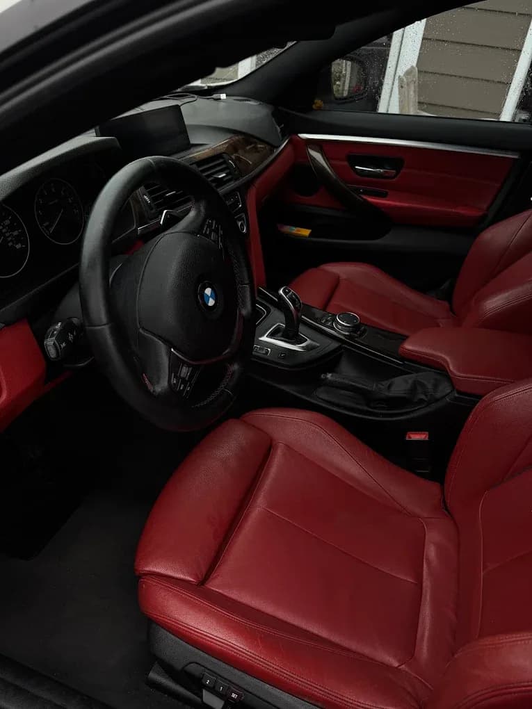 Clean red leather BMW seats, dashboard, and center console