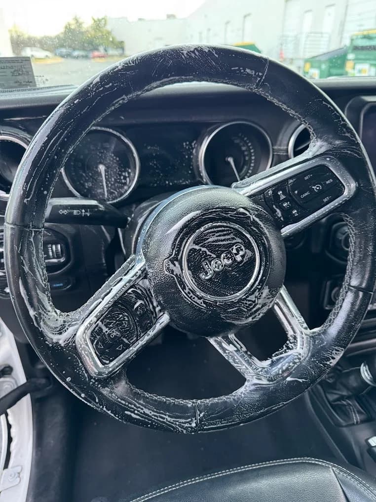 Jeep steering wheel being carefully cleaned during an interior detail